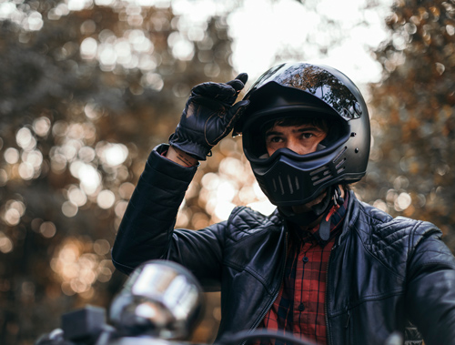 Photo of a person wearing a motorcycle helmet and leather gloves