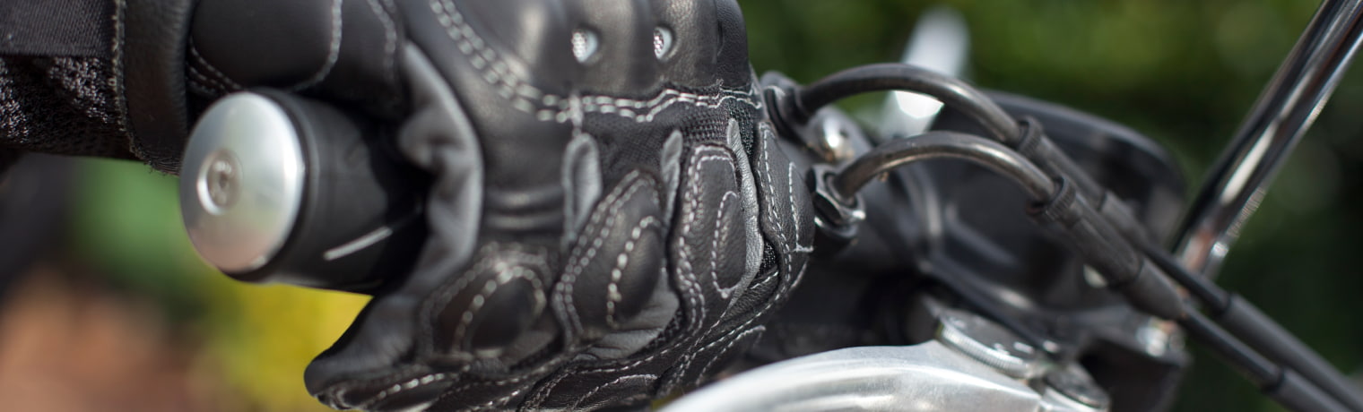 Photo of a gloved hand on motorcycle handlebars