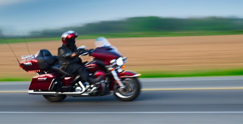 Photo of a person riding a motorcycle fast down the highway