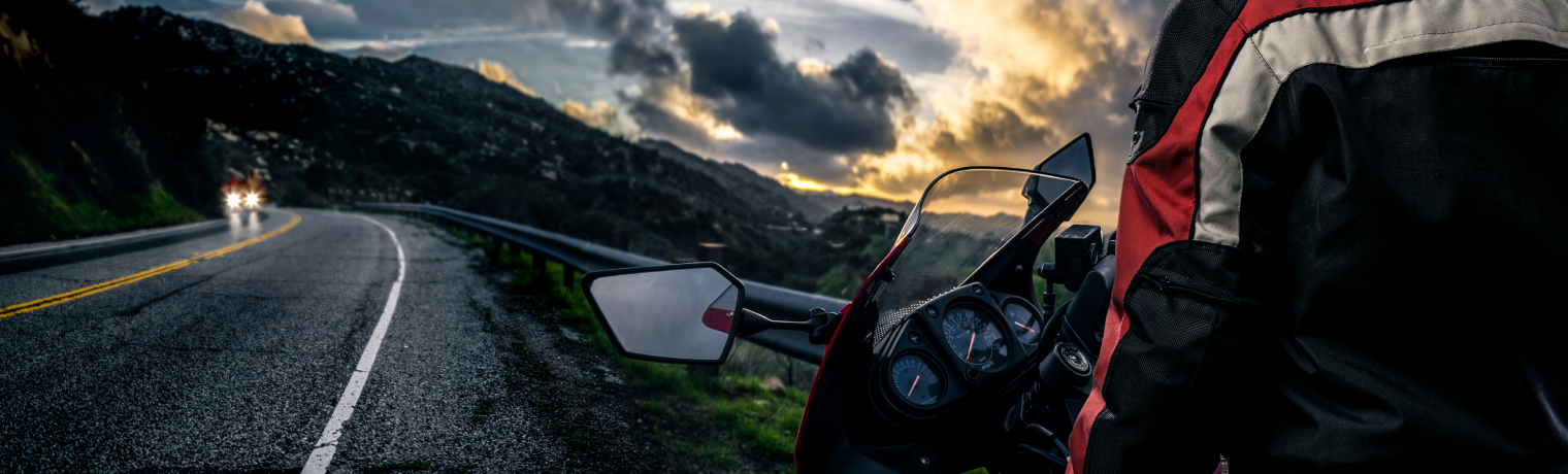 Photo of a person on a motorcycle pulled over onto the shoulder of a highway