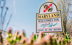 Photo of a sign that says "Maryland Welcomes You. Leave no one behind."